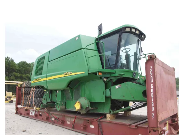 John Deere 9750 STS combine resting on a flat rack, blocked on timber and chained down