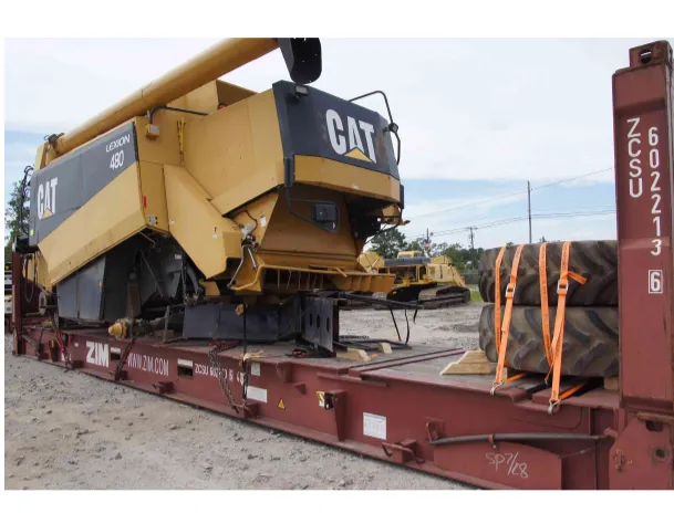 Комбайн с надписью Lexion 480 на платформе flat rack, рядом закреплены шины