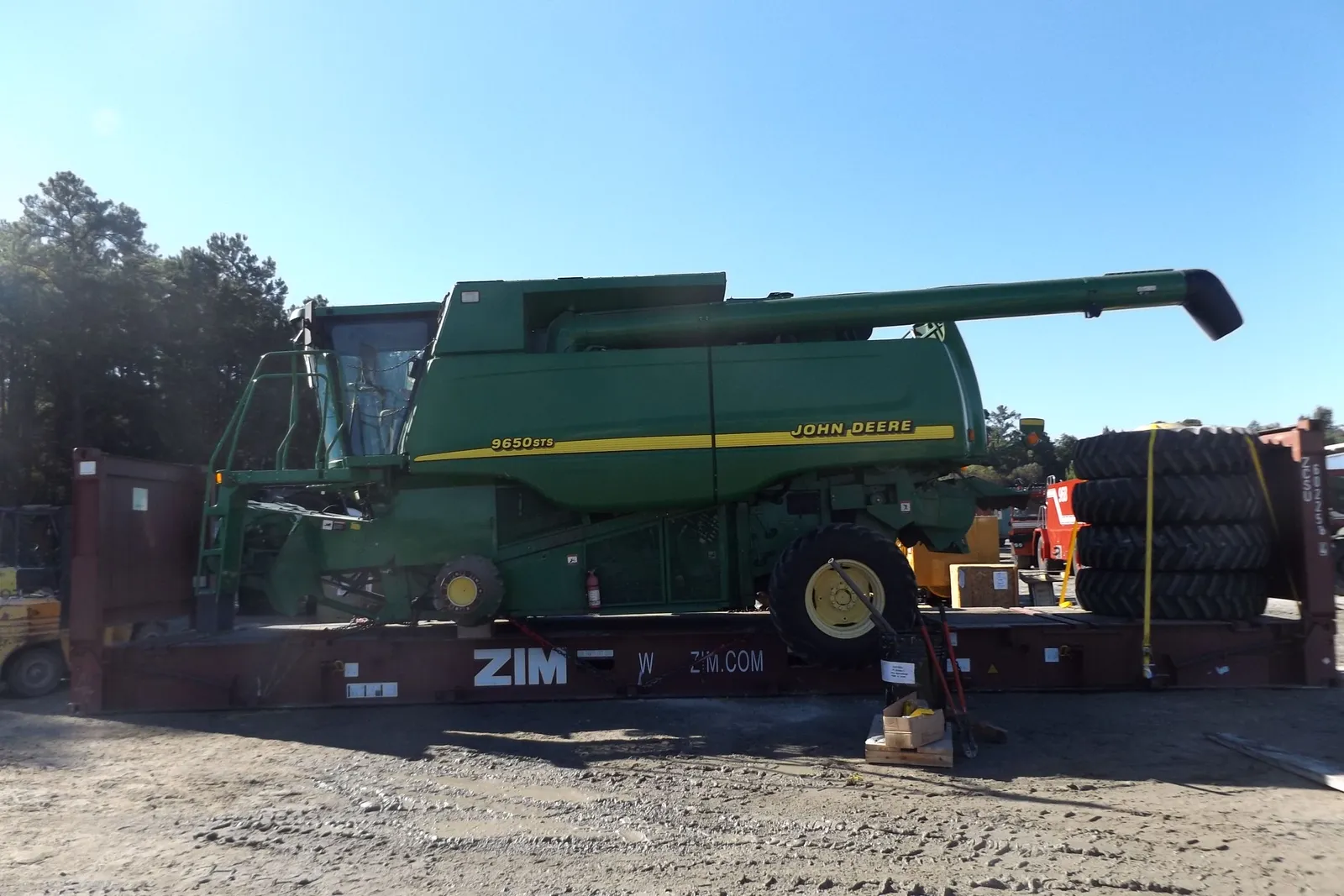 Комбайн John Deere 9650 STS на платформе Flat Rack, у правого края закреплена стопка шин