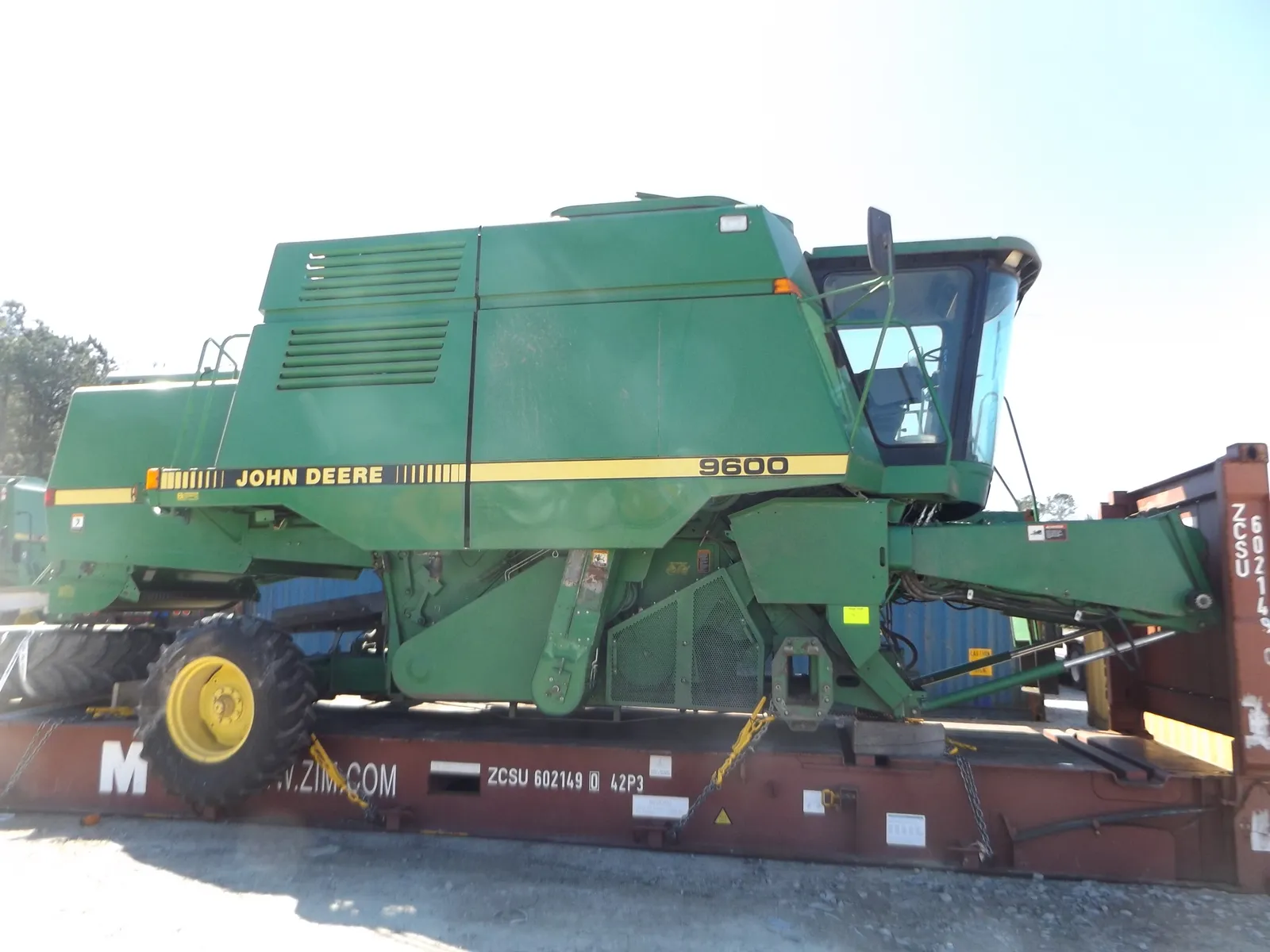 John Deere 9600 combine chained and strapped down on a Flat Rack in a container yard