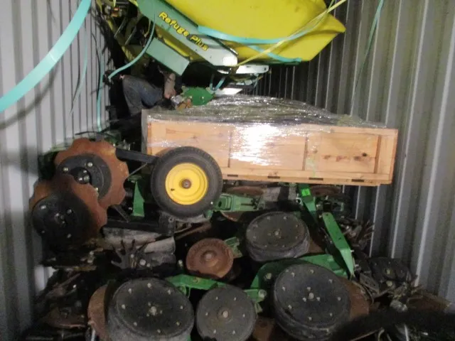 Planter row units, discs and a film-wrapped wooden crate packed tightly inside a shipping container