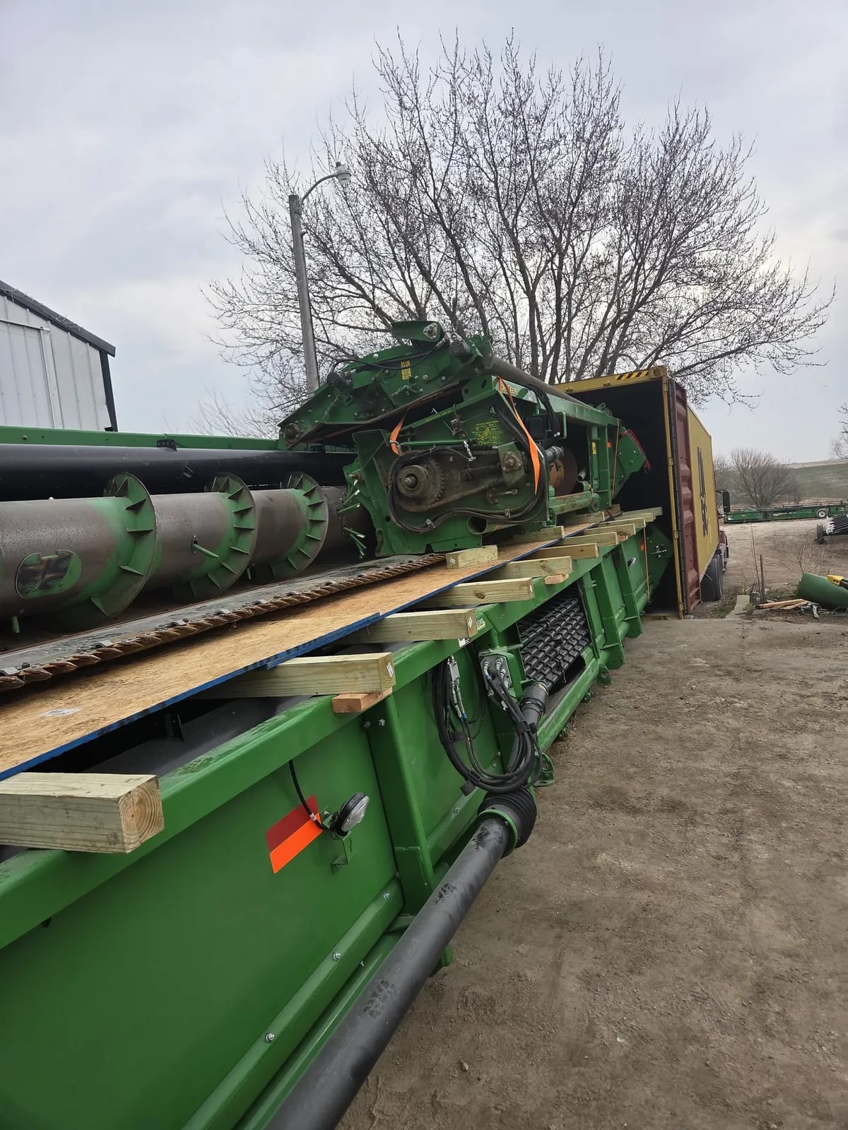 Header parts on plywood and timber laid across a header, lined up with an open container on a truck