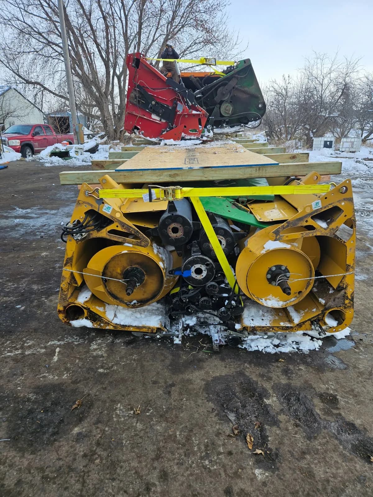 Nested yellow headers under a wooden deck, with red and green headers on top, held by a yellow strap